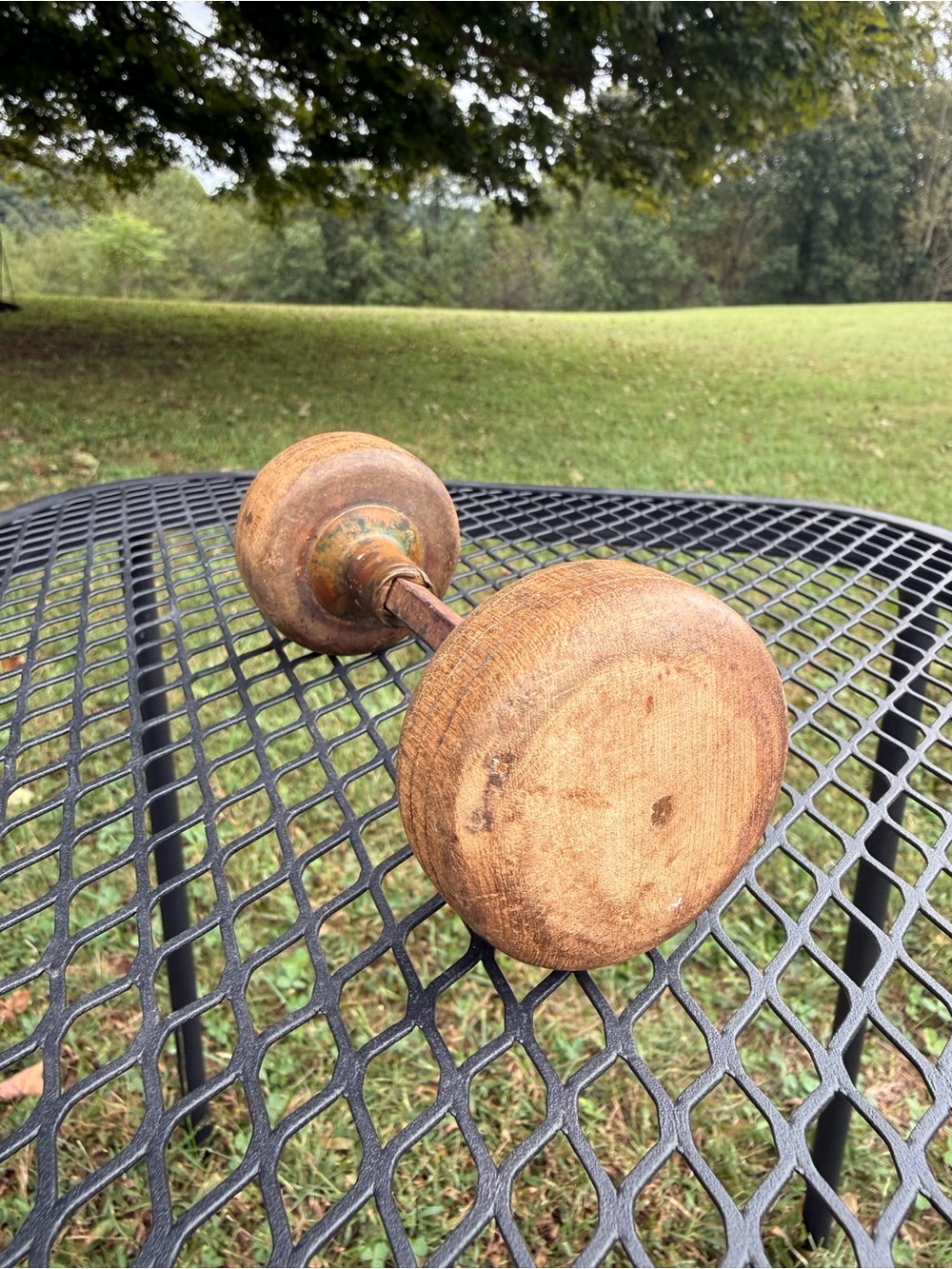pair of antique turned-wood door knobs connected by a central spindle